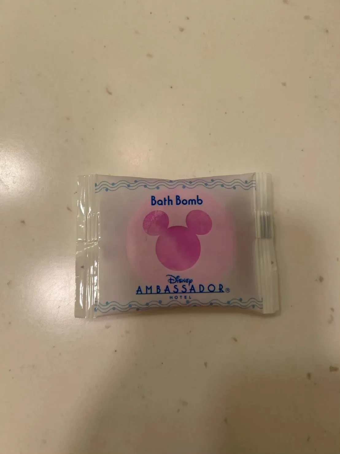 ピンクのミッキーのシルエットが見える入浴剤(Bath Bomb)の袋。ディズニーアンバサダーホテルのロゴ入り