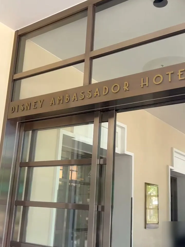 ガラス扉の上に DISNEY AMBASSADOR HOTEL の金色の文字があるホテルの入口