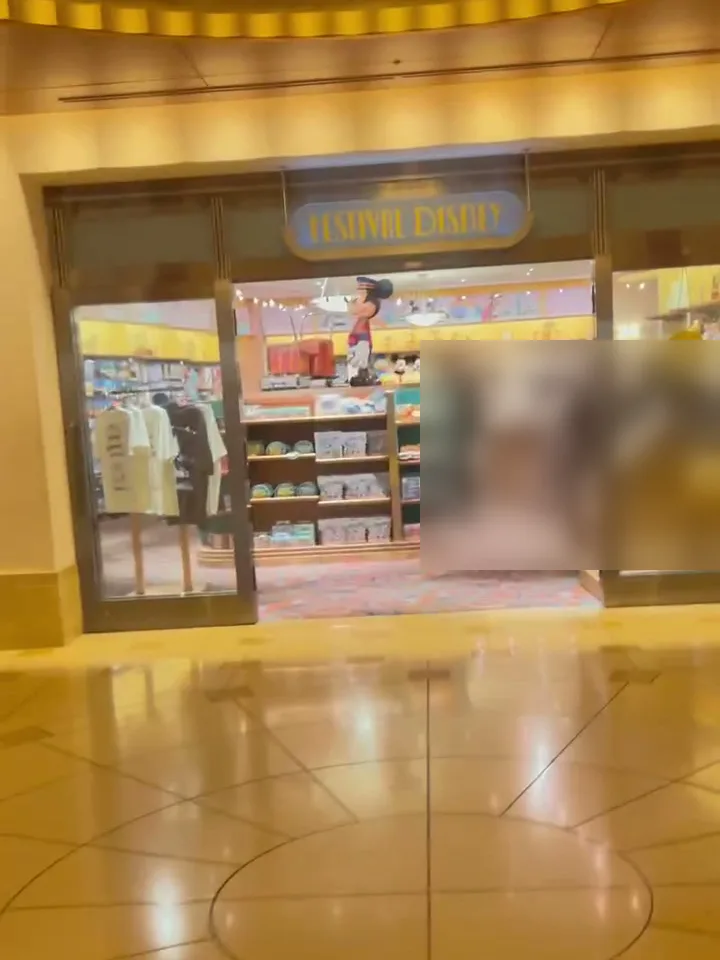 FESTIVAL DISNEY の看板があるホテル内ショップの入口。店内に洋服やお菓子の棚が並ぶ