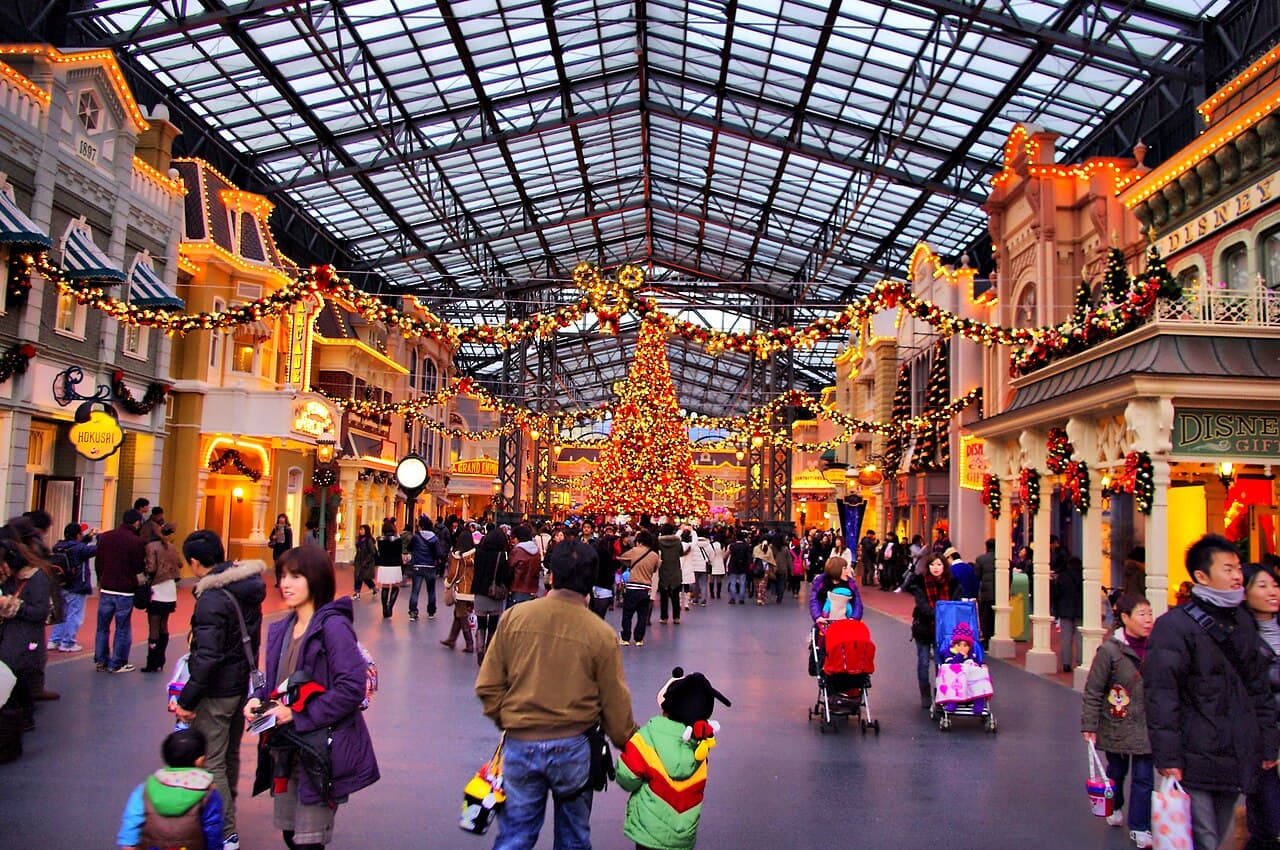 クリスマスの飾りつけをした東京ディズニーランドのワールドバザール。ガラス屋根の下、通りの奥に大きなクリスマスツリーが立っている